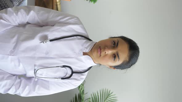 Portrait of A Young Indian Serious Woman Doctor Looking At The Camera Dressed in A Bathrobe