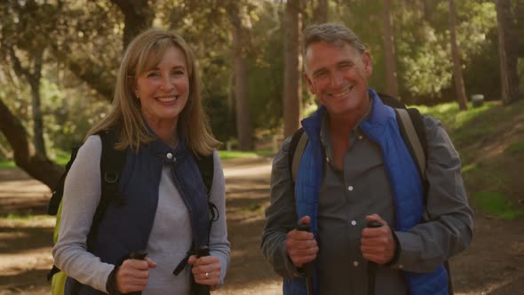 Active senior couple hiking in forest