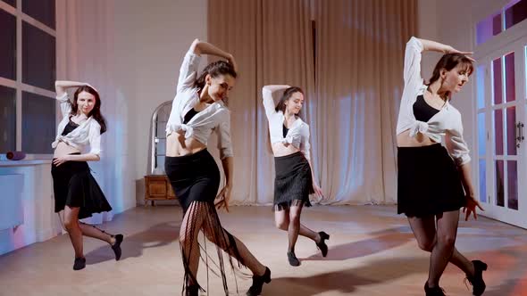 Four Girls in Black Skirts and White Shirts are Dancing Indoors