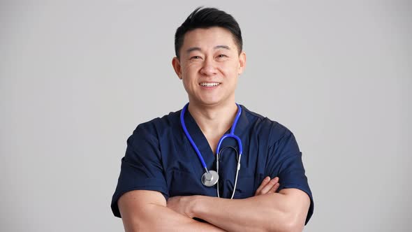 Smiling Asian doctor putting on a stethoscope