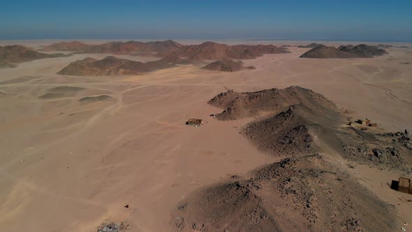 Top view of the Sahara desert, desert mountains. Wooden Bedouin houses. Sands.