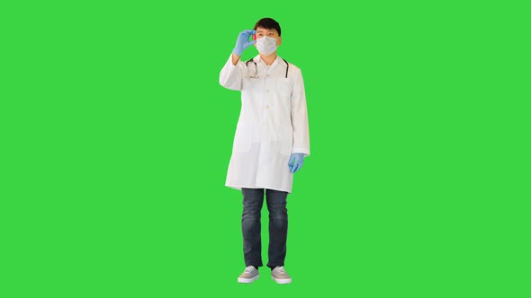 Young Asian Doctor is Showing Two Ampules with Red and Blue Solution on a Green Screen Chroma Key