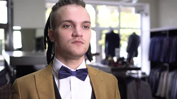 Stylish Man in Classic Suit and Bow Tie in a Clothing Store