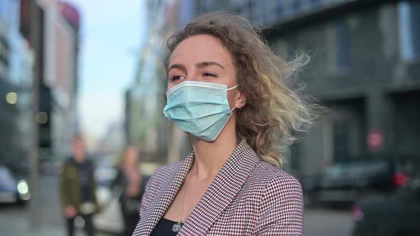 Close-up of a young woman in a jacket and a medical mask. Office worker