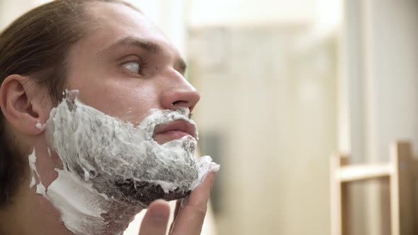 Men Hygiene. Male Applying Shaving Foam On Beard Closeup