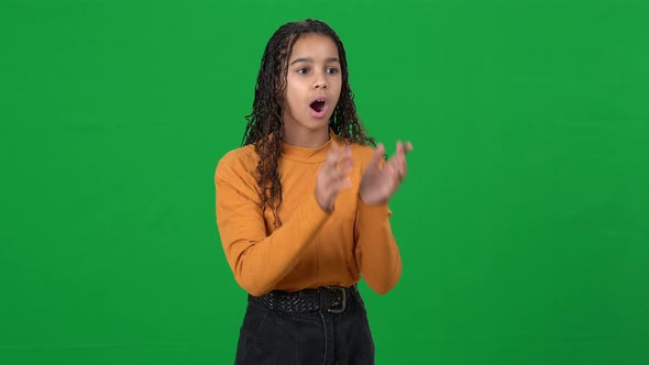 Surprised Dazed African American Teen Girl Pointing Away on Green Screen Looking at Camera