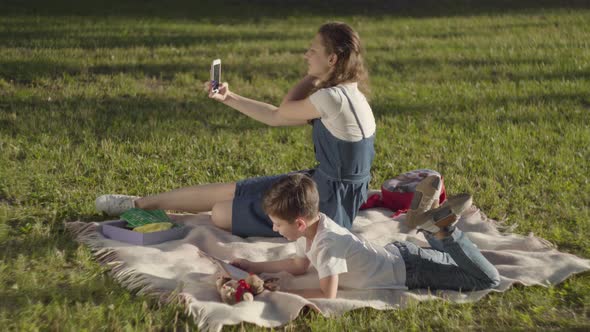 Older Sister Spending Time with Younger Brother Outdoors