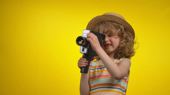 Little Girl Cinematographer in Straw Hat is Shooting Video Using Retro Camcorder