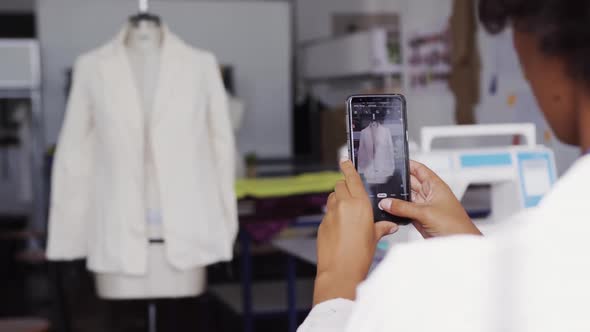 Mixed race woman taking picture in fashion office