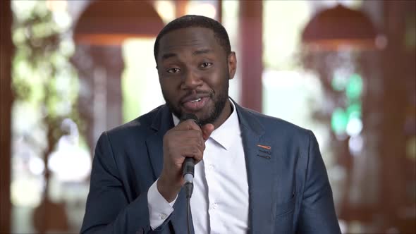 Afro-american Man Is Singing with Microphone.