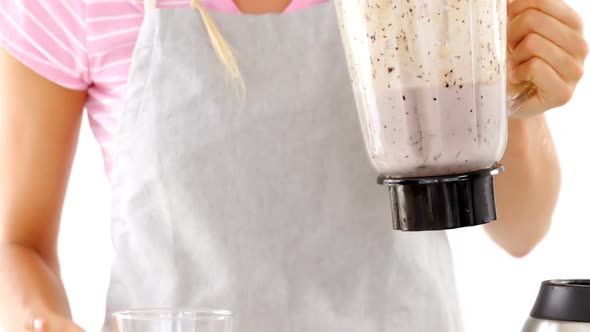 Beautiful woman pouring smoothie in glass