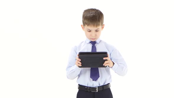 Young Businessman Reads Reports in Tablet Standing in White Studio