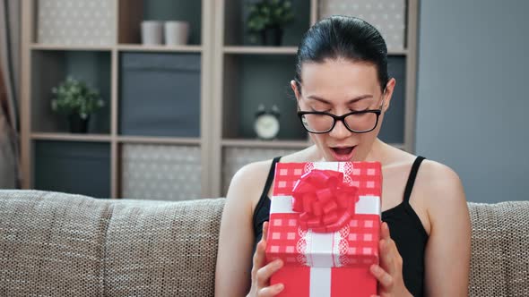 Amazement Brunette Woman Open Festive Giftbox with Bow Having Positive Emotion Celebrating Holiday