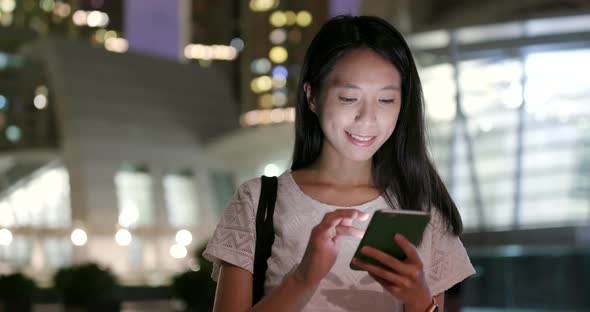 Woman use of smart phone in city at night