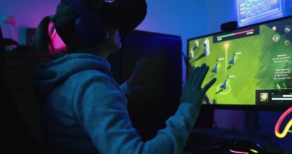 Girl gamer playing at 3D game online using virtual reality headset