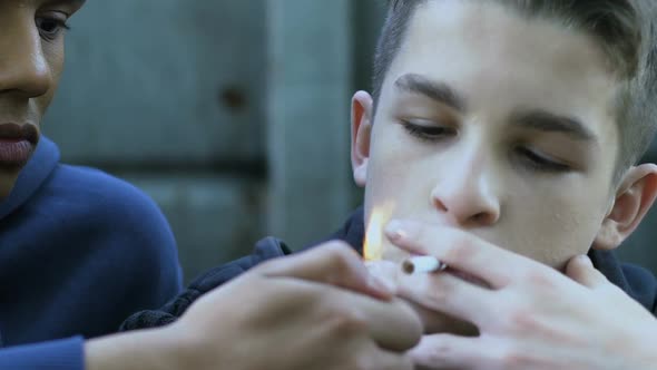 Teenager Lighting Cigarette to Classmate, Peers Pressure, Youth Bad Habits