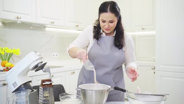 A Woman Cook Adds a Yeast and Sugar to Prepare Dough in a Mixer Bowl