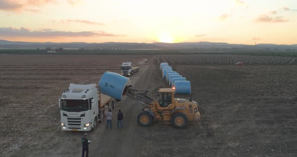 Aerial view of a tractor loading cotton bales on truck, Israel.