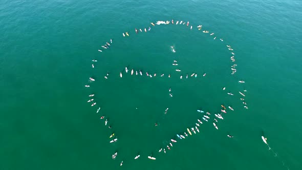 Aerial shot of surfers paddling out on the ocean.