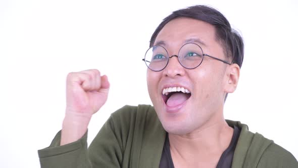 Face of Happy Japanese Man with Eyeglasses Getting Good News