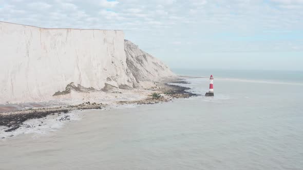 Circling drone shot around red white beachy head light house White cliffs UK