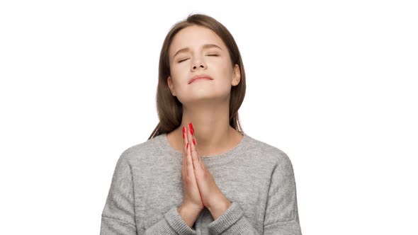 Portrait of Woman Looking Up with Closed Eyes Keeping Hands in Praying or Begging and Wishing