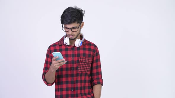 Young Happy Bearded Indian Hipster Man Using Phone