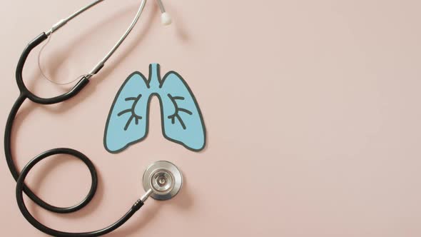 Video of close up of stethoscope with lungs on pink background