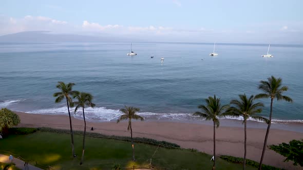 Sunrise in Hawaii with beach palm trees and boats