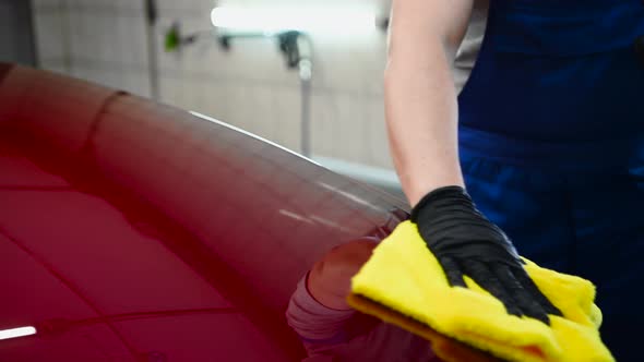 Man After Washing Wipes Red Car with a Rag at Car Wash