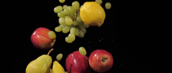 Fresh Tasty Grapes Apples Bananas Lemon and Pears Tossed Up and Fly Around on a Black Background in