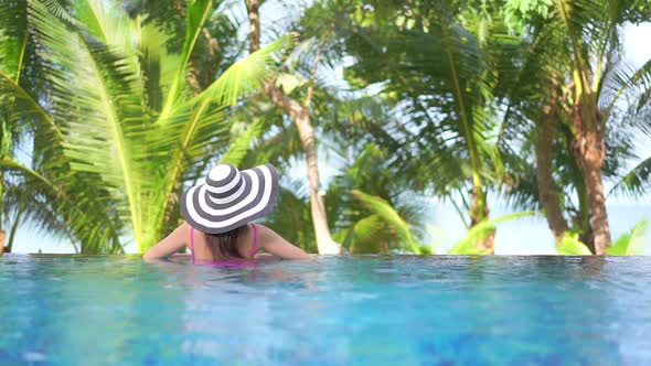 Young asian woman enjoy around outdoor swimming pool for leisure