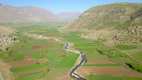 A river running in a valley of farms.