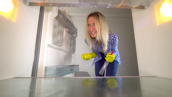 A woman looks inside the refrigerator and screams. Stress. cleaning.