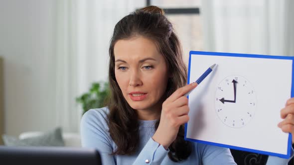 Teacher with Clock Having Online Class at Home