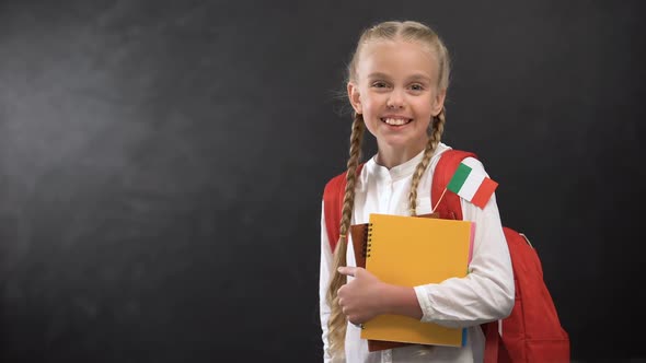 Happy Schoolgirl Holding Books With Italy Flag, Ready to Learn Foreign Language