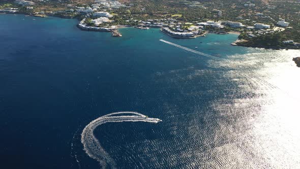 Aerial View of a Motor Boat Towing a Tube. Elounda, Crete, Greece