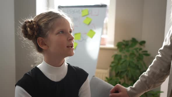 Portrait of Inspired Schoolgirl Learning Singing with Unrecognizable Music Teacher in Classroom