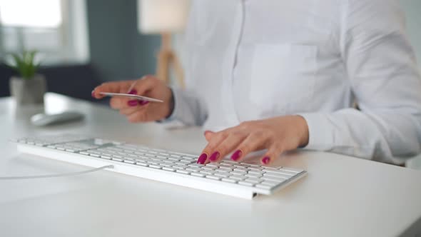 Woman Typing Credit Card Number on Computer Keyboard