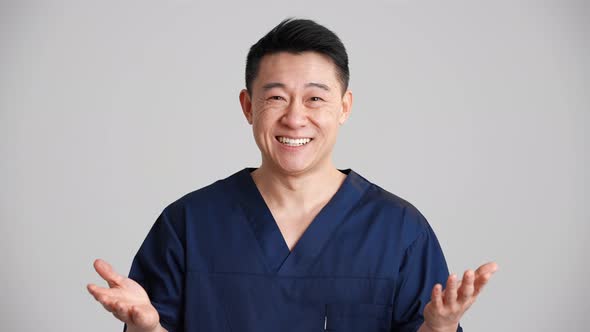 Pretty smiling Asian doctor talking something at the camera