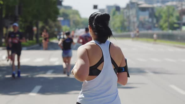 Slow Motion Woman with Smartphone Running Race