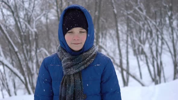 Young Teenage Boy Walks in Winter Forest