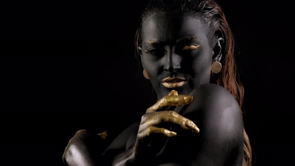 Closeup of a Young Woman with Black and Gold Paint on Her Body