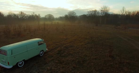 Road trip friends in hippie car. Aerial view of a retro van in fog. 