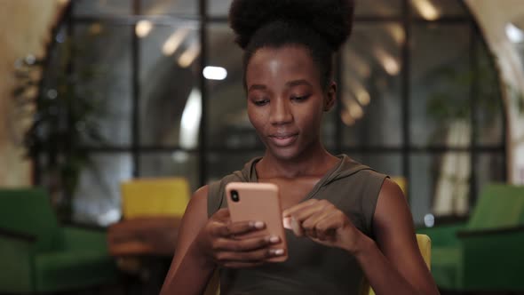 Crop View of Pretty Woman Smiling While Using Smartphone and Sitting in Cafe