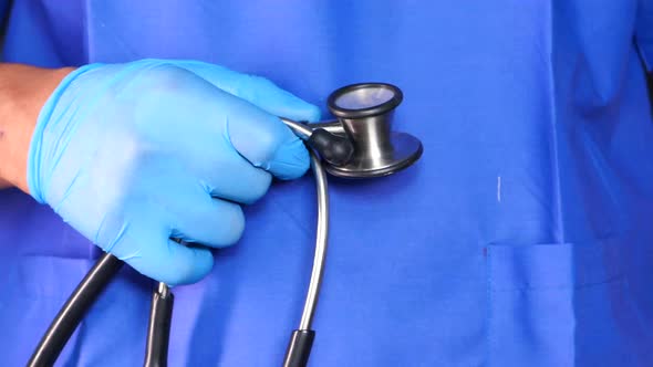 Doctor Hand in Protective Gloves Holding Stethoscope 