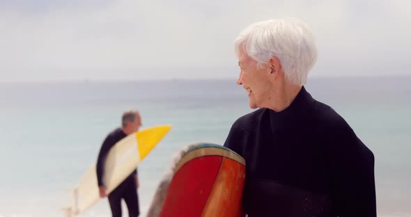 Retired Couple Holding Surfboards