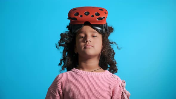 African American Girl with Virtual Reality Headset on Blue