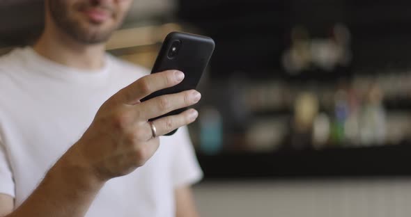 Closeup Shot of Man Hands Using Smartphone at Coffee Shop