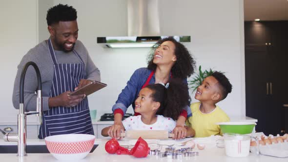 Happy african american family baking together in kitchen